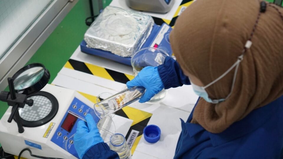 Tim R&D sedang melakukan uji formulasi sampel produk di laboratorium maklon kosmetik menggunakan peralatan steril.