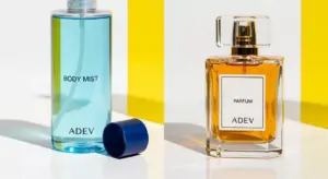 Perbandingan visual botol body mist plastik besar dan botol parfum kaca elegan buatan Adev.